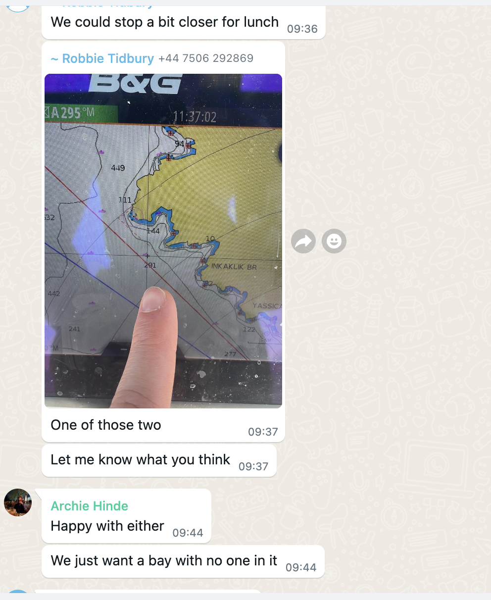 WhatsApp group chat showing skippers sharing B&G chartplotter screenshots to coordinate lunch bay selection between boats